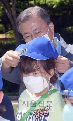 - 문재인 대통령이 5일 청와대 녹지원에서 열린 2022년 어린이날 100주년 기념 청와대 어린이 초청행사에서 어린이에게 모자를 씌워주고 있다.  2022. 5. 5 박지환 기자
