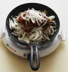 4. 볶음밥냄비에 숙주를 담고 양파, 양념에 버무린 오징어와 쇠고기를 얹는다. 대파를 얹고 물 1컵을 부어 끓인다.