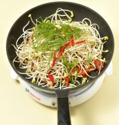 3. 넓은 팬에 돼지고기를 깔고 콩나물을 얹은 다음 떡볶이떡, 대파, 풋고추, 홍고추를 얹고 중불 익힌다.