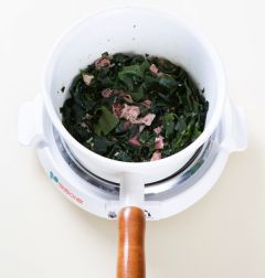 2. 냄비에 참기름을 두르고 쇠고기와 다진 마늘을 넣어 센 불에 3분 정도 볶다가 미역을 넣어 볶는다.