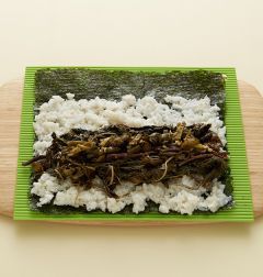 4. 나물과 다진 고추장아찌를 얹고 돌돌 말아 먹기 좋은 크기로 썬다.