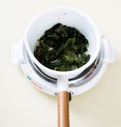 3. 냄비에 양념한 미역을 넣어 2분 정도 중간 불에 볶다가 물 1컵을 넣어 끓인다. 국물이 끓으면 물 4컵을 더 넣고 끓인다. 국물이 끓으면 은근한 불로 줄이고 10분 정도 더 끓인다. (tip. 미역이 부드러워질 때까지 10분 정도 끓인다.)