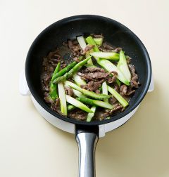 4. 팬에 식용유를 두르고 쇠고기를 넣어 1분 정도 볶다가 아스파라거스를 넣어 1분 정도 더 볶는다. 소금과 후춧가루로 간을 하고 홍고추를 넣는다.