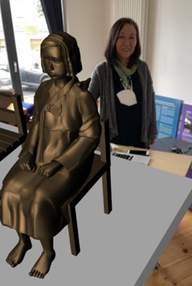 "불가능한 곳에 세울 수 있는 소녀상"(베를린=연합뉴스) 이 율 특파원 =  QR코드를 찍으면 나타나는 평화의 소녀상과 함께 선 한정화 코리아협의회 대표. 교포 2세인 강호진 디자이너가 개발한 QR코드를 활용하면 불가능한 곳에도 소녀상을 세울 수 있다. 이 QR코드는 앞으로 일본군 위안부 관련 교육프로그램에서 활용할 계획이다.