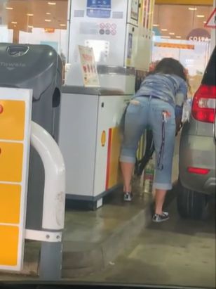 현지시간 27일 영국 런던 외곽 콥햄의 한 주유소에서 한 여성이 빈 페트병에 기름을 채우고 있다. 〈사진=영국 스카이뉴스 캡쳐〉