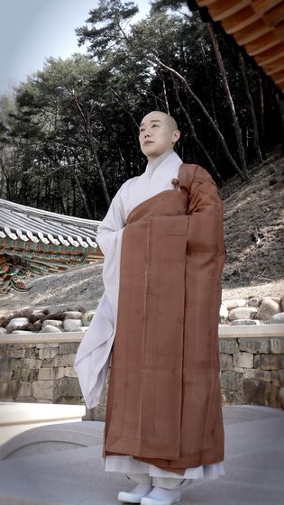 전남 구례 화엄사의 범정 스님이 가사를 수하는(걸쳐 입는) 방법을 소개하고 있다. 가사는 승려가 예식 때 승복 위에 착용하는 일종의 법의(法衣)다. 사진 서울공예박물관