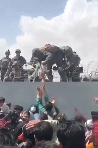 지난해 8월 말 탈레반이 아프간 수도 카불을 장악하자 시민들은 무작정 카불공항으로 몰려들었다. 필사적인 탈출 행렬이 이어지는 가운데 한 남성이 신생아를 철조망 너머 미군에게 건네고 있다. 트위터