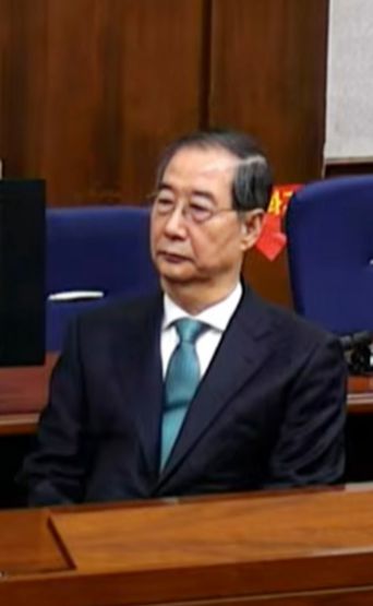 한덕수 전 국무총리가 21일 서울중앙지법에서 열린 내란 우두머리 방조와 내란 중요임무종사 혐의에 대한 1심 선고 재판에 참석해 재판장의 발언을 듣고 있다. 서울중앙지법 재판 중계 화면 캡처