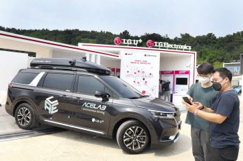 LG유플러스 관계자들이 ‘2021 서울 스마트 모빌리티 엑스포(SSME 2021)’ 전시부스에서 자율주행차를 살펴보고 있다. [LG유플러스 제공]