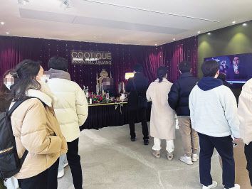 30일 서울 성동구 성수동의 삼양라면 쿠티크팝업스토어 ‘살롱드쿠티크’에서 방문객이 쿠티크 홍보 영상을 보며 포토존에서 대기하고 있다.