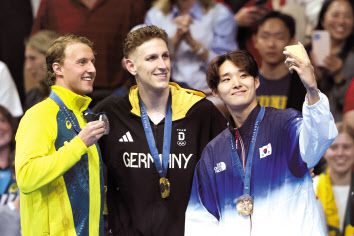 27일(현지시간) 프랑스 파리 라 데팡스 아레나에서 열린 2024 파리 올림픽 남자 자유형 400m 시상식에서 금메달 루카스 마르텐스(독일·왼쪽), 은메달 일라이자 위닝턴(호주), 동메달 김우민(오른쪽·대한민국) 선수가 시상대에서 ‘갤럭시 Z 플립6 올림픽 에디션’으로 ‘빅토리 셀피’를 찍고 있다. [삼성전자·게티이미지 제공]