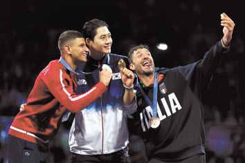 27일(현지시간) 프랑스 파리 그랑 팔레에서 열린 2024 파리 올림픽 남자 사브르 개인전 시상식에서 금메달 오상욱(가운데·대한민국), 은메달 파레스 페르자니(튀니지), 동메달 루이지 사멜레(이탈리아) 선수가 시상대에서 ‘갤럭시 Z 플립6 올림픽 에디션’으로 ‘빅토리 셀피’를 찍고 있다. [삼성전자·게티이미지 제공]