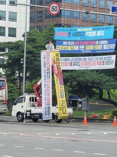 "익명출산제 폐기하고 고아특별법 제정하라"사다리차를 이용해 시위를 벌이고 있는조윤환 고아권익연대 대표 [고아권익연대 제공]