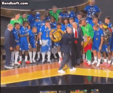 FIFA 인판티노 회장이 2025 클럽월드컵 우승팀 첼시 선수단에게 트로피를 건네고 시상대 중앙에 계속 서 있는 트럼프 대통령에게 내려오라고 손짓하는 모습./ 엑스 ' RaheemKassam'