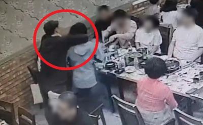 더불어민주당 소속 남성 의원이 합동 의정연수 만찬장에서 국민의힘 소속 여성 의원을 팔로 감싸고 있다. [사진출처=국민의힘 B의원 측 제공 CCTV]