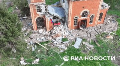 파괴된 교회 건물에서 북한군과 러시아군이 깃발을 꽂은 후 카메라를 향해 손을 흔들고 있다. /리아 노보스티