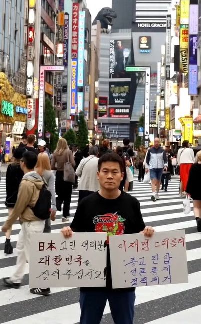 전한길 씨가 일본 도쿄 신주쿠 거리에서 손팻말을 들고 시위하는 모습. 〈사진=전한길 씨 유튜브 채널 갈무리〉