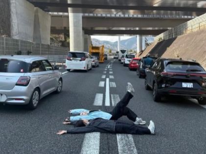 중국인 관광객들이 일본 후지산으로 향하는 고속도로 한 가운데에 드러누워 ‘인생사진’을 찍고 있는 모습. [SCMP 갈무리]