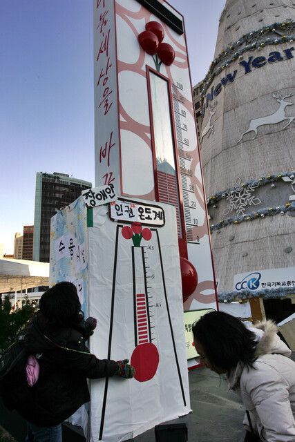 ‘사회복지시설 비리 척결과 탈시설 권리 쟁취를 위한 공동투쟁단’ 회원들이 2008년 12월22일 오후 서울 태평로 시청앞 광장에 설치된 사랑의 온도계 옆에 영하로 떨어진 ‘장애인 인권온도계’를 설치하고 있다. 김명진 기자 littleprince@hani.co.kr