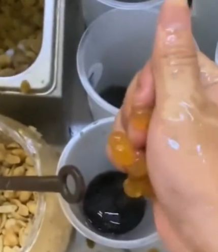 중국의 한 밀크티 가게 직원이 맨손으로 음료 컵 안에 펄을 넣는 모습. 더우인 캡처