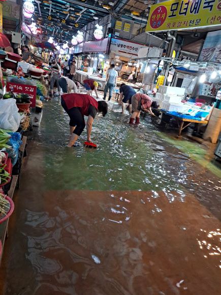 물에 잠긴 남광주시장 - 7일 오후 광주에 폭우가 내려 남광주시장에도 물이 발목까지 차오르자 상인들이 물을 퍼내고 있다. 2020.8.7.독자 제공/연합뉴스