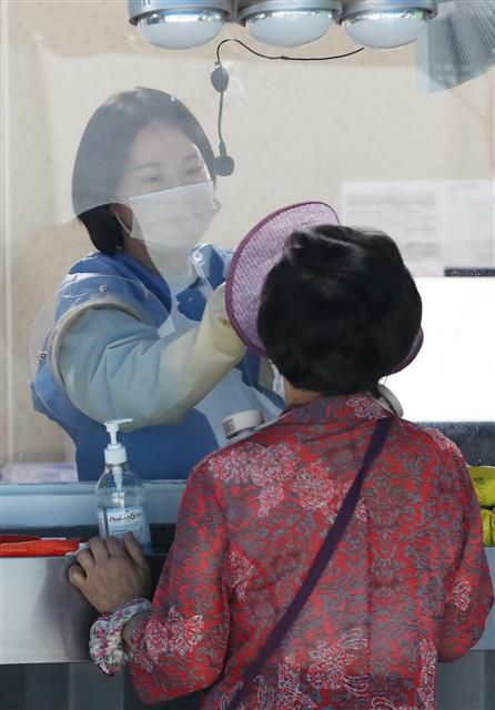 코로나19 신규확진 1만59명, 주말에도 이틀 연속 1만명대 - 3일 오전 서울 용산구보건소 신종 코로나바이러스 감염증(코로나19) 선별진료소에서 의료진이 검체검사를 하고 있다.  코로나19 유행이 반등세를 보이는 가운데 이날 신규 확진자 수는 전날에 이어 1만명대를 기록했다. 중앙방역대책본부는 이날 0시 기준으로 코로나19 확진자가 1만59명 늘어 누적 1838만9611명이 됐다고 밝혔다. 전날(1만715명)보다 656명 줄었지만 이틀 연속 1만명대를 기록했다. 2022.7.3 뉴스1