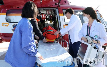 서울 강서구 이대서울병원에서 인근지역 외상 중증환자를 원내로 이송하는 상황을 가정해 열린 응급헬기환자 시뮬레이션에서 의료진과 강서소방서 구조팀 등이 훈련을 하고 있다./사진=(서울=뉴스1) 이동해 기자