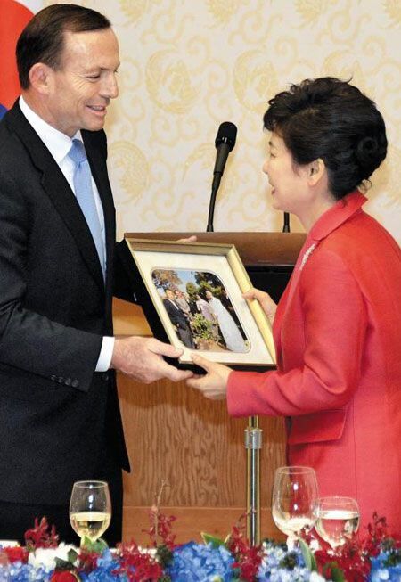 토니 애벗 전 호주 총리가 2014년 한국과 호주가 FTA(자유무역협정)를 체결할 당시 청와대에서 열린 공식 만찬에 참석해 박근혜 당시 대통령에게 박정희 전 대통령이 1968년 호주를 방문했을 당시의 사진을 선물로 건네고 있다./뉴시스