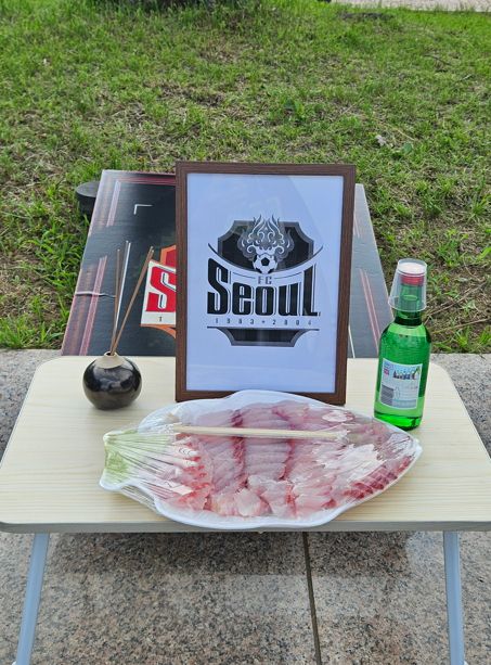 서울 팬들이 상 위에 향을 피우고 흑백으로 처리한 서울 엠블럼이 그려진 액자, 소주, 방어회 등을 올려놓고 장례식 퍼포먼스를 했다. 박린 기자