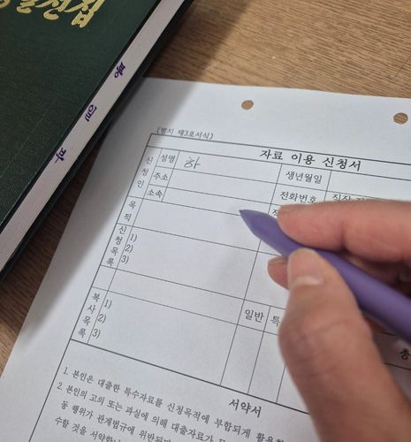 '특수자료' 복사 때 작성해야 하는 서류   (서울=연합뉴스) 하채림 기자 = 통일부 북한자료센터에서 7일 이용자가 '특수자료'인 '김정일 전집'을 복사하기 위해 '자료 이용 신청서'를 작성하고 있다.