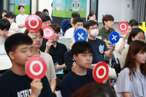 20일 서울 강남구 팁스타운에서 중소벤처기업부 주관으로 열린 ‘일상 속 골목규제 뽀개기’ 행사에 참석하 국민판정단이 규제개선안에 대해 ‘O·X’로 의사표시를 하고 있다.(사진=중소벤처기업부)