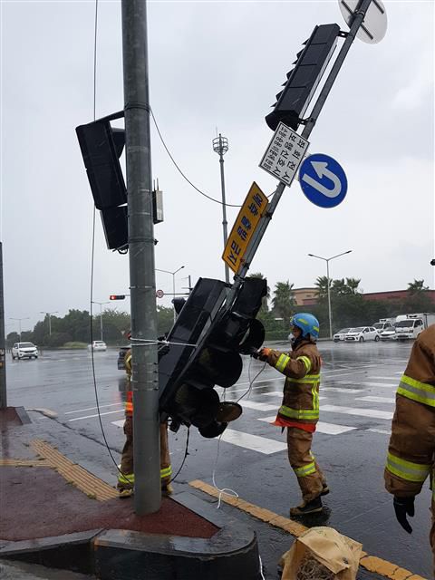 26일 제8호 태풍 ‘바비’의 영향권에 들어간 제주에서 강풍 피해가  이어지고 있다. 이날 오전 제주시 연동 도로에서 신호등이 쓰러져 소방대원들이 안전 조치를 취하고 있다. 2020.8.26. 제주소방서 제공.