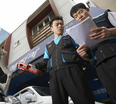 보험사 직원들이 정비업소에서 수리비 견적서를 살펴보는 모습. /KB손해보험 제공