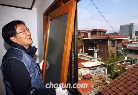 사회적 기업 ‘나눔하우징’을 이끌었던 송경용 신부가 서울 은평구의 한 연립주택에서 도배를 새로 하고 창틀을 걸고 있다. 빈민운동의 대부인 그는 협동조합, 사회연대기금을 만들어 사회적 경제 운동을 펼쳐왔다. /조선일보DB