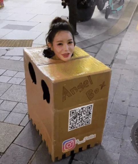 한 여성이 박스만 걸치고 있다. [사진=온라인 커뮤니티 갈무리]