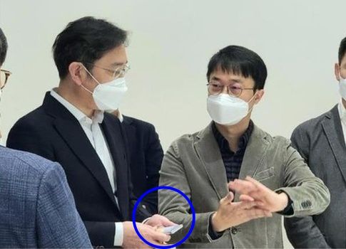 이재용 삼성전자 회장(당시 부회장, 왼쪽)이 2020년 11월 서울R&D 캠퍼스에서 열린 디자인 전략회의에서 롤러블폰으로 추정되는 차세대 스마트폰을 쥐고 있는 모습. 삼성전자 제공