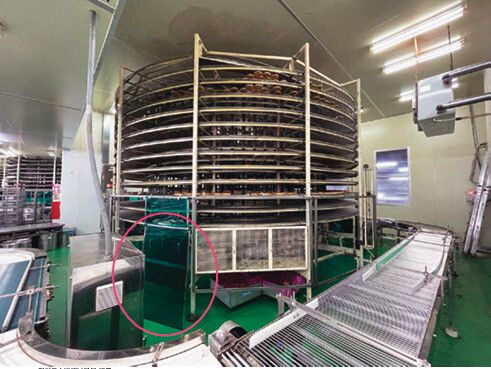 사고 기계인 냉각 스파이럴 컨베이어벨트(가운데 원통형 기계). 벨트 위에 놓인 빵이 천천히 기둥을 따라 회전하며 식는 원리다. ㄱ씨는 기계 밑으로 들어가 윤활유를 뿌렸다(동그라미 표시). 경기도소방재난본부 제공.