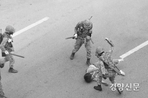 1980년 5·18민주화운동 당시 계엄군으로 투입된 공수부대가 광주 동구 금남로에서 한 시민을 곤봉으로 무자비하게 구타하고 있는 모습을 찍은 사진. 매일신문 만평과 계엄군의 행동과 구도가 같다. 5·18기념재단 제공(이창성 촬영).