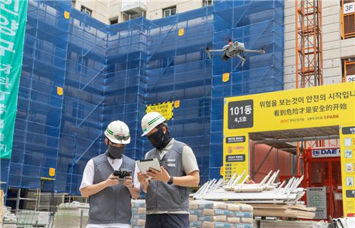 HDC현대산업개발 관계자가 한 건설 현장에서 드론을 활용해 현장을 관리하고 있다. HDC현대산업개발 제공