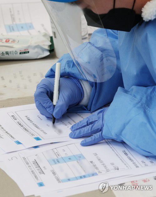 신속항원검사 음성확인서 작성하는 관계자(안성=연합뉴스) 홍기원 기자 = 오미크론 방역체계가 시작된 경기도 안성시보건소 선별검사소에서 26일 오전 관계자가 신속항원검사 음성확인서를 작성하고 있다.2022.1.26 xanadu@yna.co.kr