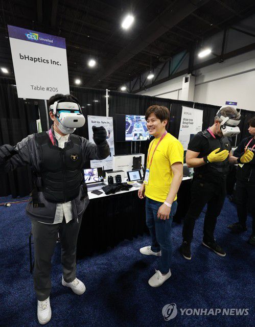 메타버스로, 관심 받는 한국 업체 실감형 수트(라스베이거스=연합뉴스) 홍해인 기자 = 세계 최대 가전·IT(정보기술) 박람회 CES 2023 개막에 앞서 3일 오후(현지시간) 미국 네바다주 라스베이거스 만달레이 베이 컨벤션 센터에서 열린 'CES 2023 사전 공개(UNVEILED)' 행사에서 각국 미디어 관계자들이 국내 기업인 비햅틱스(bHaptics)가 진동으로 촉감을 전달하는 '택트글러브'와 '택트수트'를 체험해 보고 있다. 이 장갑을 끼고 조끼를 입은 뒤 가상세계에 접속해 광선검을 휘두르면 맞은 상대방은 충격을 느낄 수 있다. 2023.1.4 hihong@yna.co.kr