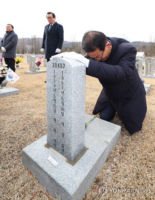 용서와 화해의 눈물(서울=연합뉴스) 김도훈 기자 = 5·18 공법단체 관계자들이 5·18 당시 숨진 특전사와 경찰관 묘역 참배에 나선 17일 오후 서울 동작구 국립서울현충원 사병 묘역에서 황일봉 5·18 부상자회 회장(오른쪽)이 헌화를 마친 뒤 묘비를 어루만지며 눈물을 흘리고 있다. 2023.1.17 superdoo82@yna.co.kr