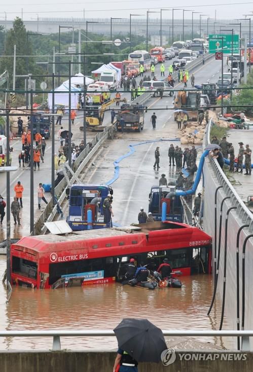 배수 작업으로 모습 드러난 침수 버스   (청주=연합뉴스) 김주형 기자 = 16일 미호천 제방 유실로 침수된 충북 청주시 오송읍 궁평2지하차도에서 버스 등 침수 차량에 대한 인명 수색이 진행되고 있다. 2023.7.16     kjhpress@yna.co.kr