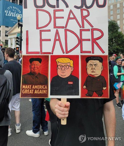 트럼프-김정은 '합성' 만화 그려진 피켓 든 시위 참가자(워싱턴=연합뉴스) 조준형 특파원 = 14일(현지시간) 워싱턴 DC에서 열린 미 육군 창설 250주년 기념 열병식을 앞두고 백악관 인근 라파예트 광장에서 반(反)트럼프 시위가 열렸다.      한 시위 참가자가 트럼프 대통령과 김정은 북한 국무위원장의 얼굴을 '합성'한 만화가 그려진 피켓을 들고 있다. 2025.6.15 jhcho@yna.co.kr