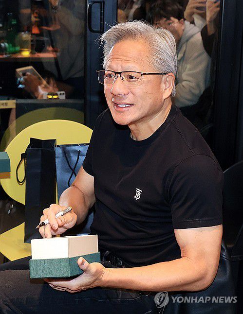 선물에 사인하는 젠슨 황(서울=연합뉴스) 이진욱 기자 = 젠슨 황 엔비디아 최고경영자가 30일 오후 서울 삼성역 인근 치킨 매장에서 진행된 이재용 삼성그룹 회장, 정의선 현대차그룹 회장과의 회동 중 선물에 사인을 하고 있다. 2025.10.30 [공동취재] cityboy@yna.co.kr