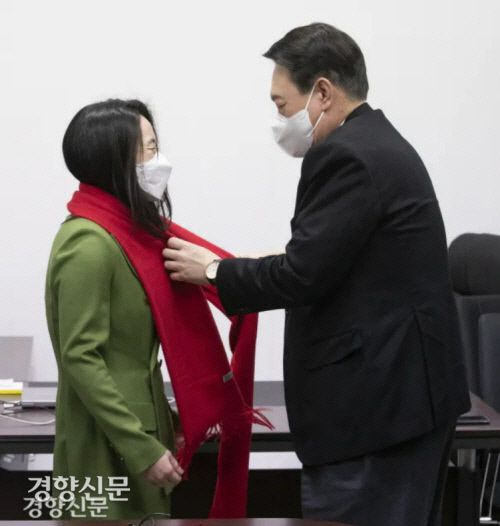 윤석열 국민의힘 대선후보가 지난달 20일 서울 여의도 새시대준비위원회 사무실에서 영입된 신지예 한국여성정치 네트워크 대표에게 환영의 목도리를 걸어주고 있다. 국회 사진기자단