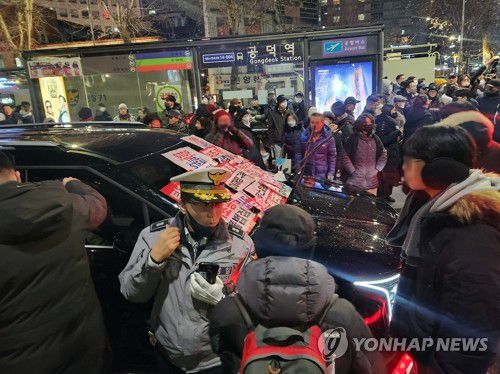 (서울=연합뉴스) 김준태 기자 = 내란 우두머리 혐의로 체포된 윤석열 대통령의 구속 전 피의자심문(영장실질심사)이 종료된 18일 밤 서울 마포구 공덕역 인근에서 윤 대통령 지지자들이 고위공직자범죄수사처(공수처) 추정 차량의 앞을 막고 있다.　2025.1.18 readiness@yna.co.kr