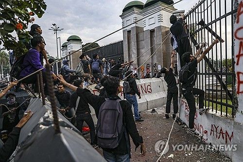 2025년 3월 20일, 인도네시아 자카르타에서 군법 개정에 반대하는 시위대가 국회의사당 울타리를 허물려고 하고 있다. [EPA=연합뉴스]