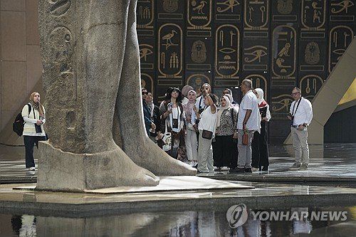 이집트 대박물관에서 람세스 2세 동상을 바라보고 있는 관광객들. 연합뉴스