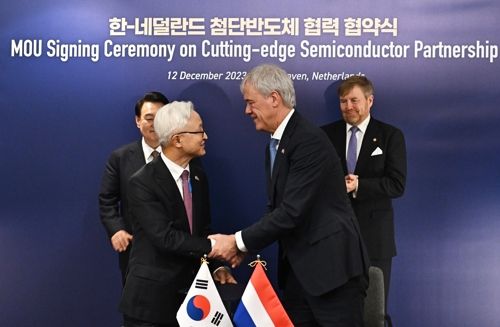 경계현 삼성전자 사장과 피터 베닝크 ASML 최고경영자(CEO)가 12일(현지시간) 네덜란드 벨트호벤 소재 ASML 본사에서 차세대 반도체 제조기술 R&D센터 설립 양해각서(MOU)를 체결한 뒤 악수하고 있다. 이 체결식에는 네덜란드를 국빈 방문 중인 윤석열 대통령과 빌럼-알렉산더르 네덜란드 국왕도 배석했다. [사진출처 = 연합뉴스]